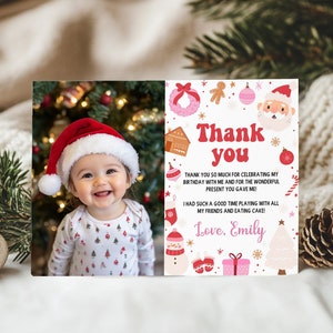 May include: A rectangular thank you card featuring a photo of a smiling baby wearing a red and white Santa hat on the left. The right side has a white background with red text reading Thank you, Love, Emily, and various Christmas icons.