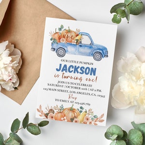 May include: A rectangular birthday invitation card featuring a watercolor illustration of a blue pickup truck carrying pumpkins and flowers. The text reads: OUR LITTLE PUMPKIN JACKSON is turning one! JOIN US TO CELEBRATE SATURDAY | OCTOBER 10th | AT 2 PM. 123 MAIN STREET, LOS ANGELES, CA. 12345 RSVP TO EMILY AT 123-456-789.