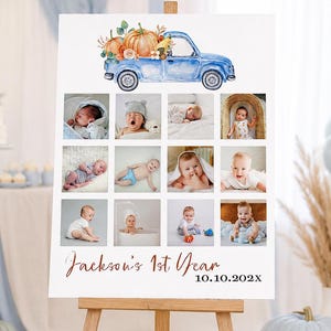 Könnte beinhalten: Ein weißes rechteckiges Schild auf einer Holzstaffelei mit einer Aquarellillustration eines blauen Lastwagens mit Kürbissen. Darunter befinden sich zwölf quadratische Fotorahmen eines Babys sowie der Text Jackson's 1st Year und 10.10.202X.