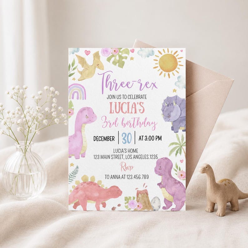 May include: A rectangular birthday invitation card featuring watercolor illustrations of dinosaurs, a sun, a rainbow, and foliage. The text reads: Three-rex, JOIN US TO CELEBRATE LUCIA'S 3rd birthday, DECEMBER 30 AT 3:00 PM, LUCIA'S HOME, 123 MAIN STREET, LOS ANGELES.1235, RSVP TO ANNA AT 123.456.789.
