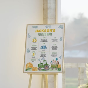 May include: A rectangular birthday milestone sign for Jackson's first birthday featuring a green tractor, hay bales, and farm animals. The text includes weight in pounds, height in inches, favorite foods, songs, toys, and nickname on a white background.