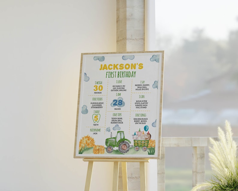 May include: A rectangular birthday milestone sign for Jackson's first birthday featuring a green tractor, hay bales, and farm animals. The text includes weight in pounds, height in inches, favorite foods, songs, toys, and nickname on a white background.