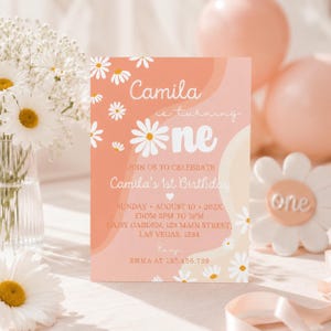 Peut inclure: Une carte d'invitation d'anniversaire rectangulaire avec un fond p&ecirc;che et cr&egrave;me et des marguerites blanches. Le texte indique : Camila is turning one, Join us to celebrate Camila's 1st Birthday, Sunday, August 10, 202X, from 2pm to 5pm, Daisy Garden, 123 Main Street, Las Vegas, 1234, RSVP Emma at 123.456.789.