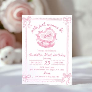May include: Pink and white invitation card with a pink heart-shaped cake with bows and the text "girls just wanna be one" and "Charlotte's First Birthday" with details for the party on 23rd January.