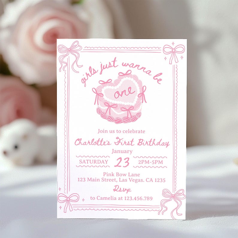 May include: Pink and white invitation card with a pink heart-shaped cake with bows and the text "girls just wanna be one" and "Charlotte's First Birthday" with details for the party on 23rd January.