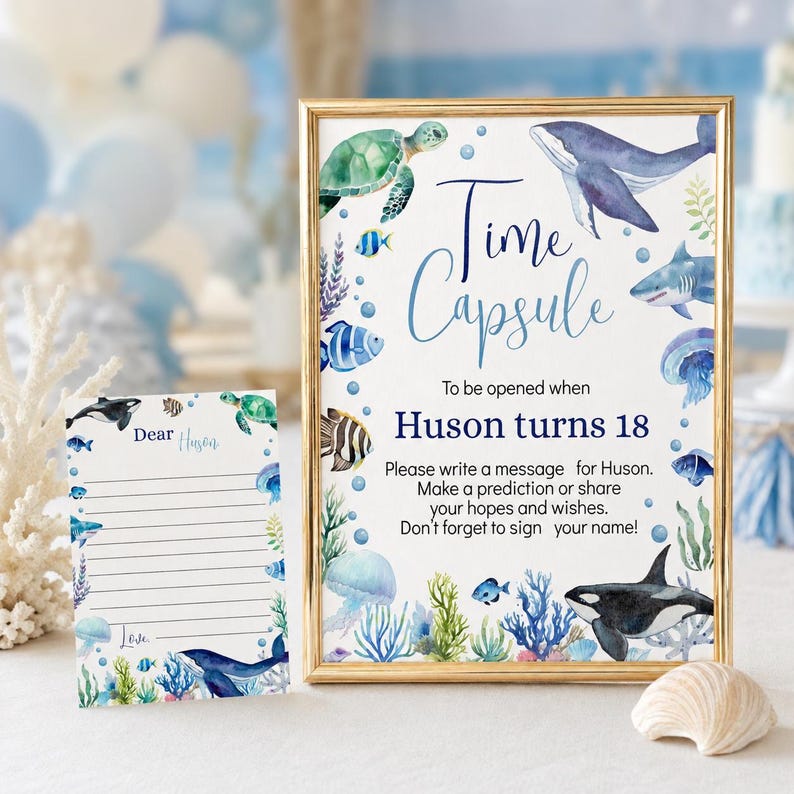 Pu&ograve; includere: Un cartello con cornice dorata e un biglietto abbinato con illustrazioni ad acquerello di vita marina, tra cui una balena, una tartaruga, uno squalo e una medusa. Il cartello recita Time Capsule To be opened when Huson turns 18. Il biglietto dice Dear Huson.