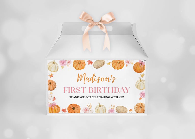 May include: A white gable gift box with a light pink satin ribbon bow on top. The front features a border of watercolor pumpkins, pink roses, and autumn leaves, with the text "Madison's FIRST BIRTHDAY THANK YOU FOR CELEBRATING WITH ME!"