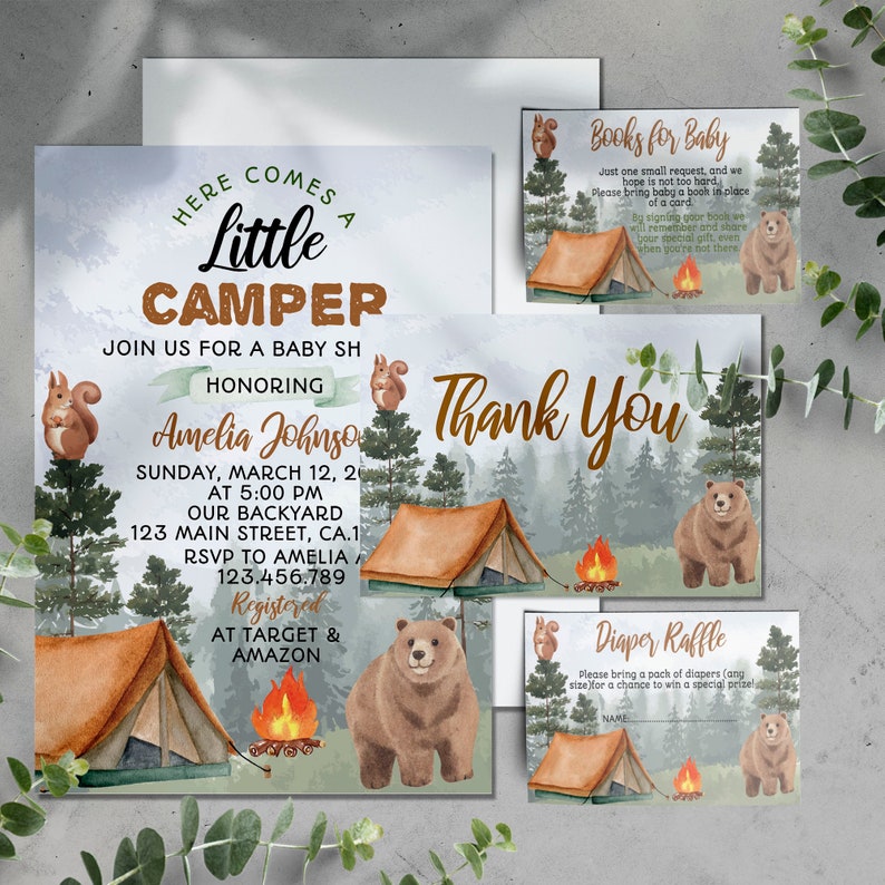 May include: A baby shower invitation with a woodland theme. The invitation features a watercolor illustration of a tent, a campfire, a bear, and a squirrel. The text on the invitation reads "Here comes a little camper" and "Join us for a baby shower honoring Amelia Johnson".