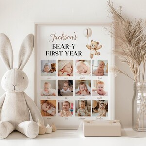May include: A white poster featuring a brown teddy bear holding a balloon with the number 1 on it. The poster reads "Jackson's BEAR-Y FIRST YEAR" and includes a grid of 12 photos of a baby boy.