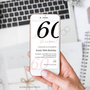 K&ouml;nnte beinhalten: Ein wei&szlig;es Smartphone mit einer digitalen Einladung zum 60. Geburtstag. Auf dem Bildschirm steht in gro&szlig;er schwarzer Schrift 60, Shhh... it's a surprise!, Emily' 60th Birthday sowie Veranstaltungsdetails wie Datum, Uhrzeit und Ort.