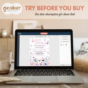 May include: A laptop screen displaying a digital birthday invitation template featuring pink and purple butterflies and floral illustrations. The text reads Our Little Butterfly Is Turning One, Amelia's 1st Birthday, and event details.