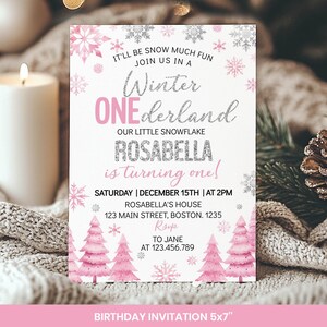 May include: A rectangular birthday invitation card featuring pink and silver snowflake illustrations, pink watercolour pine trees, and text that reads: IT'LL BE SNOW MUCH FUN JOIN US IN A Winter ONEderland OUR LITTLE SNOWFLAKE ROSABELLA is turning one!