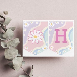May include: Two rectangular pennant flags featuring a pastel wavy background of pink, lavender, and light blue. The left flag displays a large white daisy with a yellow center, while the right flag features a bold, solid pink capital letter H.