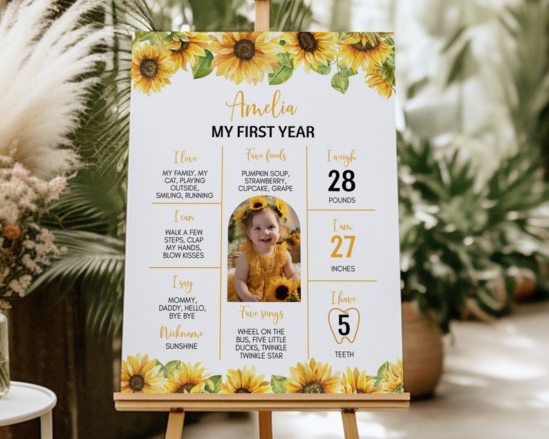 May include: A white poster with a sunflower border and a photo of a baby girl. The poster is titled "Amelia My First Year" and includes details about the baby's age, weight, height, and favorite things. The poster is perfect for a first birthday party.