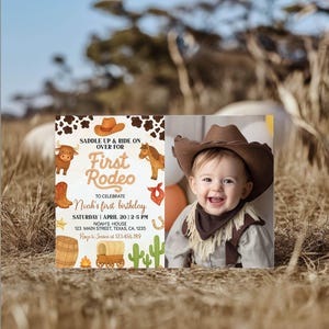 May include: A rectangular birthday invitation card featuring a western theme with cow print, a brown cowboy hat, a bull, a horse, boots, a bandana, a barrel, a wagon, and cacti. The text reads: SADDLE UP & RIDE ON OVER FOR First Rodeo TO CELEBRATE Noah's first birthday.