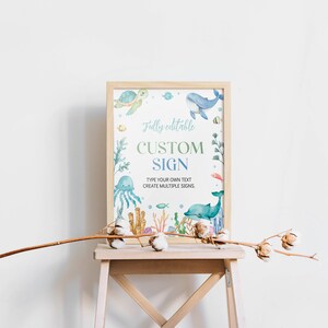 May include: A printable sign with a watercolor illustration of ocean animals, including a whale, dolphin, turtle, jellyfish, and coral. The sign says "Fully editable CUSTOM SIGN TYPE YOUR OWN TEXT CREATE MULTIPLE SIGNS".