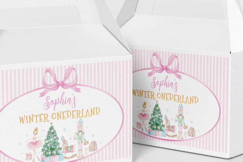 May include: Two white cardboard gable boxes featuring a pink striped border and a central oval frame. The design includes a pink bow, the text "Sophia's WINTER ONEDERLAND," a ballerina, a Christmas tree, a nutcracker, and gift boxes.