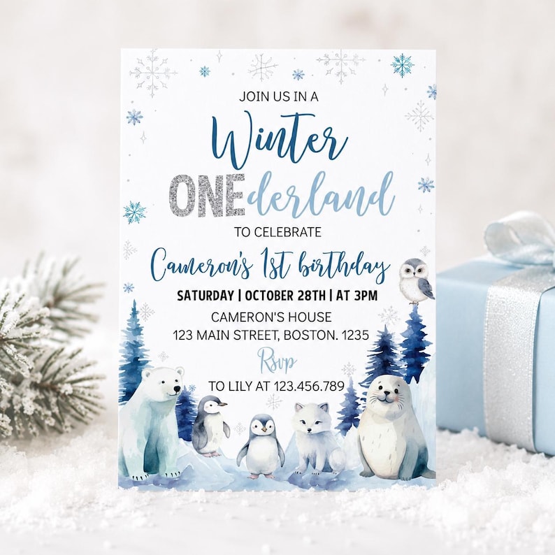 May include: A rectangular invitation card with a white background featuring blue and silver snowflake accents. The text reads: JOIN US IN A Winter ONEderland TO CELEBRATE Cameron's 1st birthday. It includes event details and watercolor arctic animals.