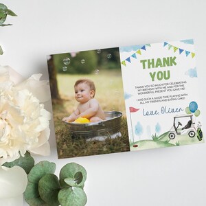Pode incluir: Um cart&atilde;o de agradecimento com uma foto de um beb&ecirc; em uma banheira com bolhas. O cart&atilde;o tem um fundo aquarela verde e azul com um carrinho de golfe e o texto "Obrigado" e "Com amor, Oliver".