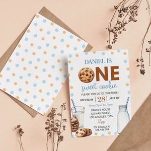 May include: A birthday invitation with a cookie theme. The invitation reads "DANIEL IS ONE sweet cookie" with a chocolate chip cookie graphic. The invitation is white with blue and gold polka dots. An envelope with a polka dot pattern is also visible.