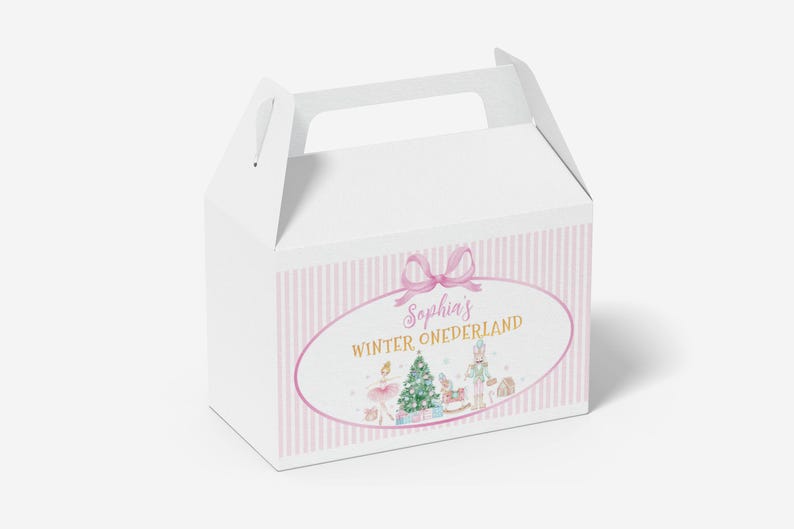 May include: A white gable box featuring a pink and white vertical striped pattern. The front displays an oval frame with a pink bow, containing the text "Sophia's WINTER ONEDERLAND" above illustrations of a Christmas tree, a nutcracker, and a ballerina.