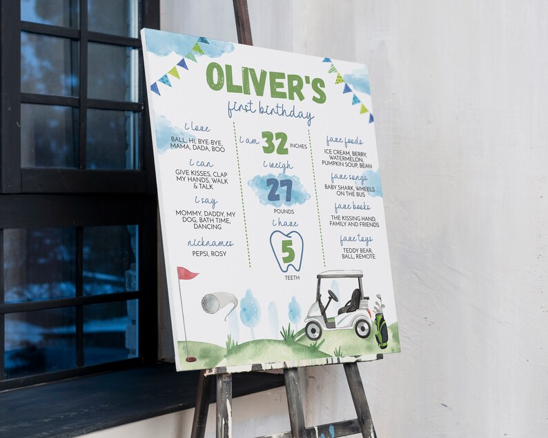 May include: A watercolour-style first birthday sign for a boy named Oliver. The sign features a golf buggy, a golf club, and a tooth with the number 5 on it. The sign also includes information about Oliver's age, height, weight, and favourite foods, songs, books, and toys.