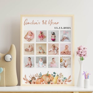 May include: A framed photo collage print titled Amelia's 1st Year with the date 11.11.202x. The poster features twelve square photographs of a baby in various outfits and poses, arranged in a grid, with a watercolor pumpkin and floral border.