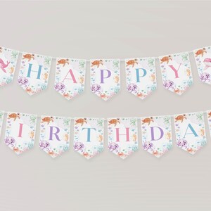 Peut inclure: Une banni&egrave;re blanche et bleue avec les mots "Happy Birthday" en lettres roses, bleues et violettes. La banni&egrave;re est d&eacute;cor&eacute;e de cr&eacute;atures marines, y compris des hippocampes, des &eacute;toiles de mer et des tortues.