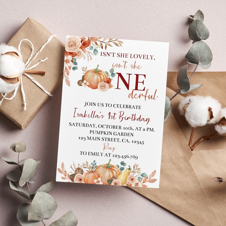 May include: A rectangular birthday invitation card featuring watercolour illustrations of pumpkins, flowers, and eucalyptus leaves. The text reads: ISN'T SHE LOVELY, isn't she NE derful, JOIN US TO CELEBRATE Isabella's 1st Birthday, SATURDAY, OCTOBER 10th, AT 2 PM, PUMPKIN GARDEN, 123 MAIN STREET, CA. 12345, RSVP TO EMILY AT 123.456.789.
