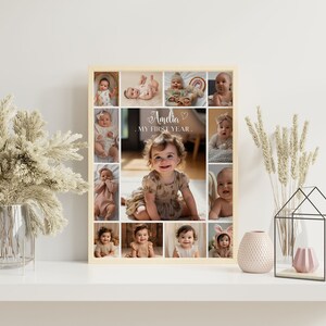 May include: A framed collage of photos of a baby girl, with the text "Amelia - My First Year." The collage is in a light wood frame and has a white background.