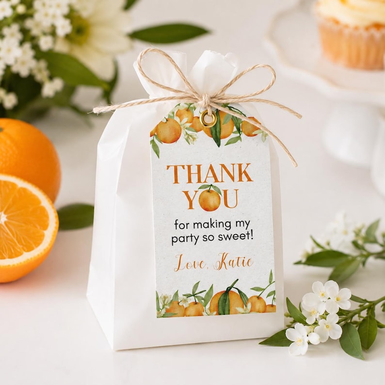Pu&ograve; includere: Un sacchetto regalo in carta bianca chiuso da un fiocco in spago color corda, con un cartellino rettangolare illustrato con arance e foglie. Il testo recita: THANK YOU for making my party so sweet! Love, Katie. Il sacchetto &egrave; opaco.