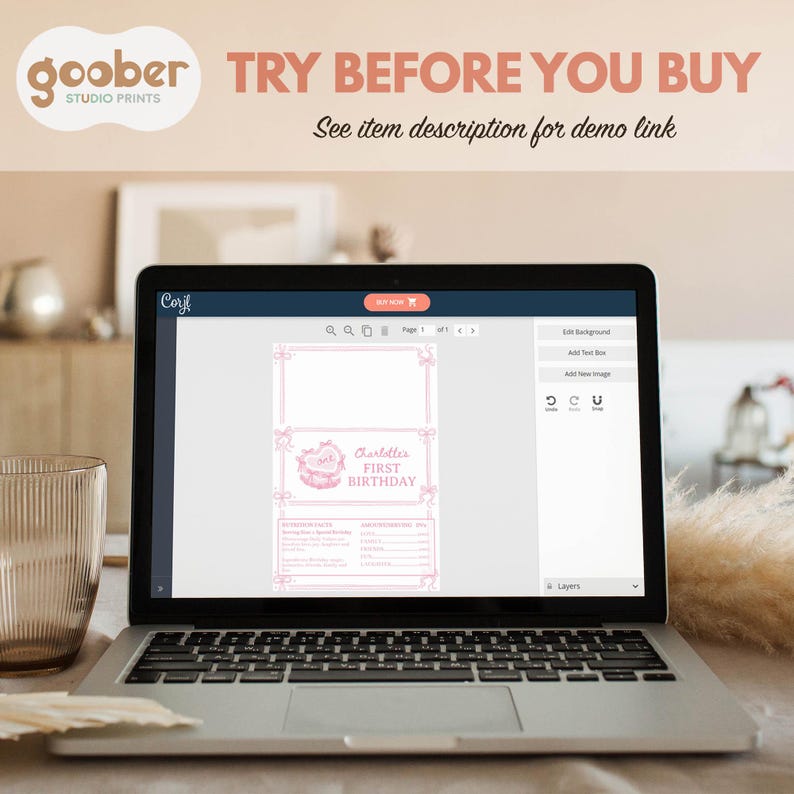 May include: A laptop screen displaying a digital design interface for a pink-themed first birthday invitation. The screen shows text reading Charlotte's FIRST BIRTHDAY, nutrition facts, and a bow-adorned border. The top banner says TRY BEFORE YOU BUY.
