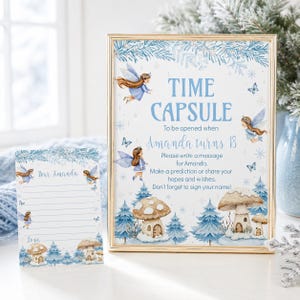 May include: A gold-framed sign and a matching card featuring blue fairy illustrations, mushrooms, and pine trees. The sign reads: TIME CAPSULE To be opened when Amanda turns 18. Please write a message for Amanda. Make a prediction or share your hopes and wishes. Don't forget to sign your name!
