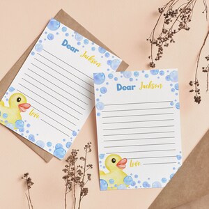 May include: Two blank stationery note cards with blue and white bubble designs and a yellow rubber duck illustration. The cards say "Dear Jackson" and "Love" at the bottom.