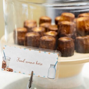 May include: A glass display case filled with small, round, brown pastries. A sign with the text "Food name here" is attached to the front of the case.