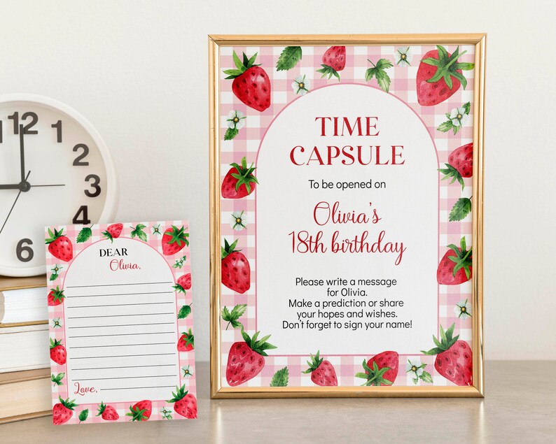 May include: A time capsule sign and a matching message card featuring a pink and white gingham background with watercolor strawberry illustrations. The sign reads: TIME CAPSULE To be opened on Olivia's 18th birthday. Please write a message.