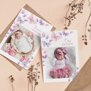 May include: Two baby milestone cards with watercolor butterfly designs. The first card says "Newborn 25.08.202" and features a photo of a baby sleeping in a basket. The second card says "One Month" and features a photo of a baby wearing a pink tutu and a headband.