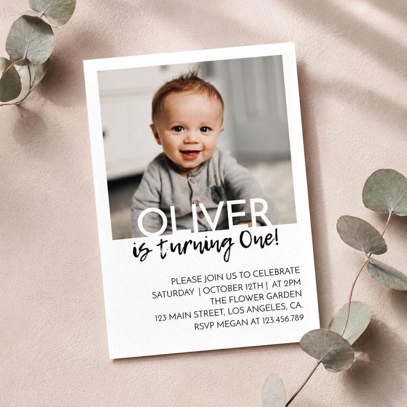 Op de afbeelding: Een rechthoekige verjaardagsuitnodigingskaart met een foto van een baby. De tekst luidt OLIVER is turning One! gevolgd door evenementdetails zoals zaterdag 12 oktober om 14:00 uur, The Flower Garden, 123 Main Street, Los Angeles, CA.