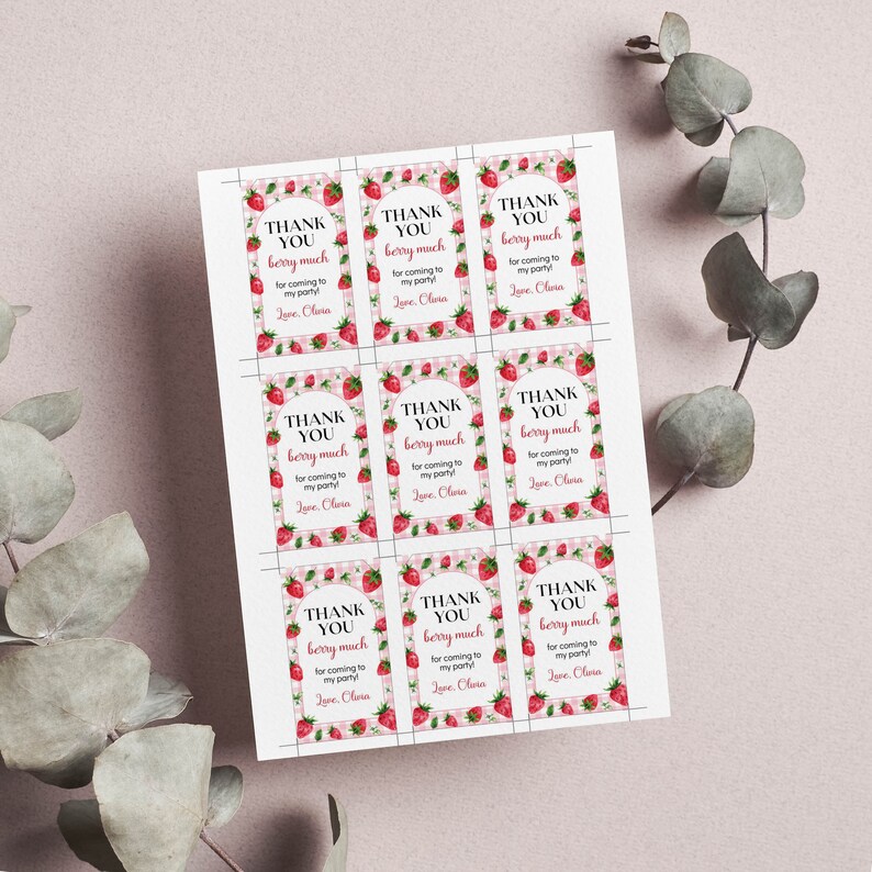 May include: A printable sheet of nine rectangular gift tags featuring a pink and white gingham border decorated with red strawberries. Each tag displays the text THANK YOU berry much for coming to my party! Love, Olivia in black and red font.
