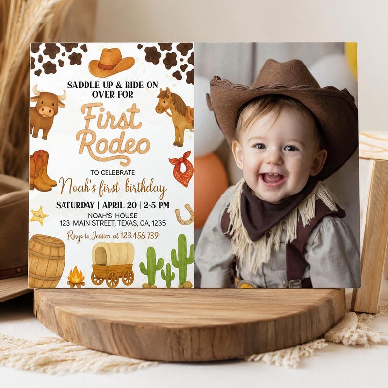 May include: A rectangular birthday invitation card featuring a western theme with illustrations of a cow, horse, boots, barrel, wagon, and cactus. The text reads: Saddle up & ride on over for First Rodeo to celebrate Noah's first birthday.