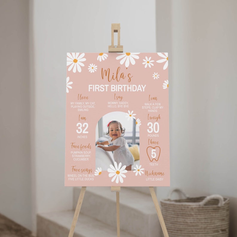 K&ouml;nnte beinhalten: Ein rosa-wei&szlig;es Poster zum ersten Geburtstag mit einem G&auml;nsebl&uuml;mchen-Motiv. Das Poster zeigt ein Foto eines kleinen M&auml;dchens sowie Details zu ihrem ersten Lebensjahr, darunter ihre Gr&ouml;&szlig;e, ihr Gewicht, ihre Lieblingsessen und Lieder. Der Text auf dem Poster lautet "Mila's First Birthday".
