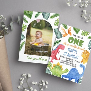 May include: Two rectangular birthday invitation cards featuring watercolor dinosaur illustrations and tropical leaves. One card displays a photo of a child in a tub with the text See you there. The other card reads Come join us for ONE dino-mite time! Henry's 1st Birthday.