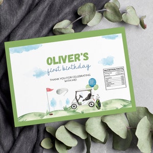 May include: A green-bordered invitation with the text "Oliver's first birthday" and a golf theme. The design includes a golf cart, a flag, and a golf ball. The invitation also has a "Nutrition Facts" section.