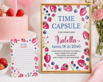 May include: A gold-framed sign and a matching card featuring watercolor strawberries and blueberries. The sign reads: TIME CAPSULE TO BE OPENED WHEN Isabella turns 18 in 2040. PLEASE WRITE A MESSAGE FOR ISABELLA. MAKE A PREDICTION OR SHARE YOUR HOPES AND WISHES.
