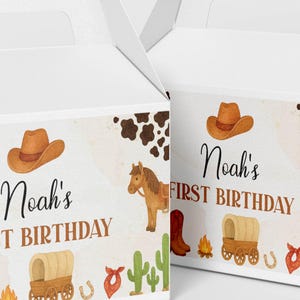 Puede incluir: Dos cajas de cart&oacute;n blanco con asa, decoradas con un estampado de tem&aacute;tica western que incluye un sombrero de vaquero marr&oacute;n, un caballo, una carreta, una fogata, un cactus y un pa&ntilde;uelo rojo. El texto dice Noah's FIRST BIRTHDAY en letras.
