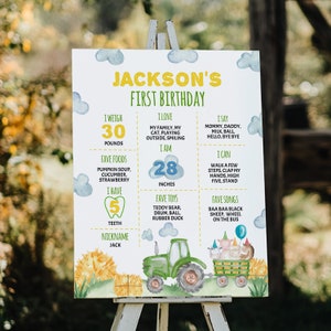 May include: A white birthday milestone sign for Jackson featuring a green tractor pulling a wagon with farm animals, blue watercolor clouds, and yellow text. It lists stats including 30 pounds, 28 inches, 5 teeth, favorite foods, toys, and songs.