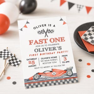 May include: A birthday party invitation with a race car theme. The invitation reads "Oliver is a Fast One" and includes details for a first birthday party. The design features a red race car and checkered flag accents.