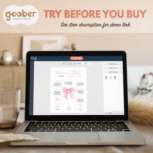 May include: A laptop displays a pink and white first birthday milestone poster with the text "Juliann's ONE" and "WHOLE YEAR". The poster includes measurements in inches and pounds. The top of the image reads "TRY BEFORE YOU BUY".