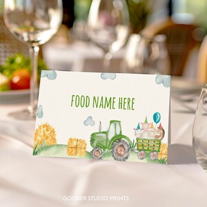 May include: Green tractor with a bale of hay and farm animals on a blue and white background. The text "FOOD NAME HERE" is printed on the card.