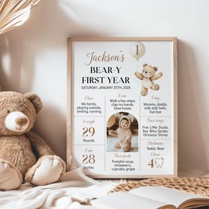 May include: A beige and brown printable poster with a picture of a teddy bear holding a balloon. The poster is a first birthday milestone chart for a baby named Jackson. It includes information about the baby's weight, height, favorite foods, songs, and activities. The poster has the text "Jackson's Bear-Y First Year" at the top.